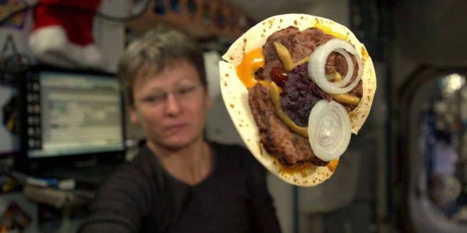 La comandante de la Expedición 51, Peggy Whitson, muestra la hamburguesa que preparó con una tortilla