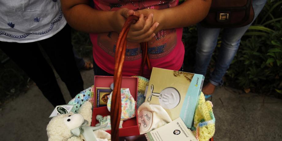 Un niña con una cesta con productos para bebé durante una protesta contra el aborto en El Salvador, mayo de 2013