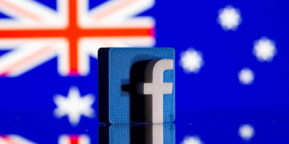 El logotipo de Facebook se ve delante de una bandera australiana desplegada.